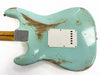 Back of relic light blue electric guitar body with worn paint and wood patches, white plastic backplate, and bolt-on maple neck with skunk stripe