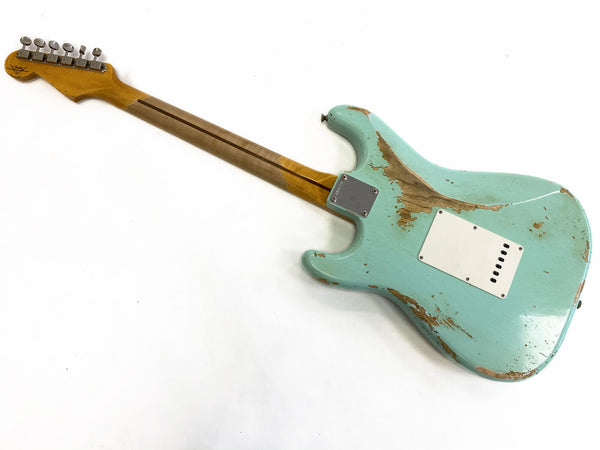 Vintage relic turquoise electric guitar body with maple neck and chrome tuning pegs, back view isolated on white background