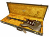 Vintage Fender Stratocaster electric guitar in metallic finish with tortoiseshell pickguard, displayed inside original yellow velvet-lined Fender hard case