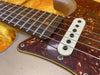 Close-up of electric guitar fretboard, tortoiseshell pickguard, and single-coil pickup with metal strings and dot inlays on rosewood fingerboard