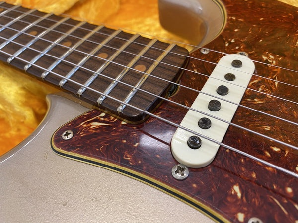 Close-up of electric guitar fretboard, tortoiseshell pickguard, and single-coil pickup with metal strings and dot inlays on rosewood fingerboard