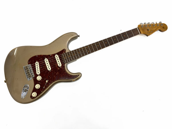 Vintage Fender Stratocaster electric guitar with worn brown body, tortoiseshell pickguard, and rosewood fretboard against white background