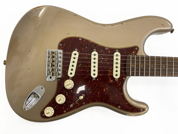 Vintage Fender Stratocaster electric guitar with relic Gold finish, tortoiseshell pickguard, three single-coil pickups, and rosewood fretboard
