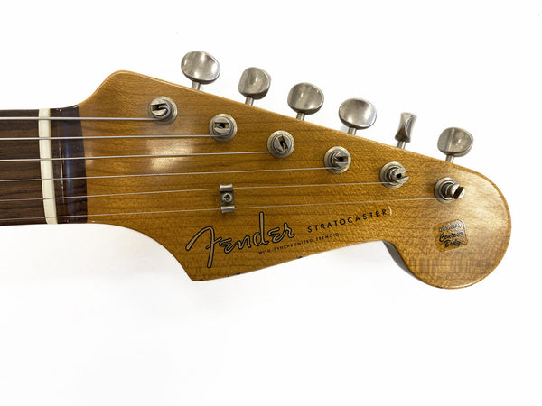 Close-up of vintage Fender Stratocaster guitar headstock with six tuning pegs and original contour body logo on natural wood finish
