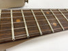 Close-up of guitar fretboard with metal frets and dot inlays on wooden neck, steel strings visible, Coffee House Guitars product detail image
