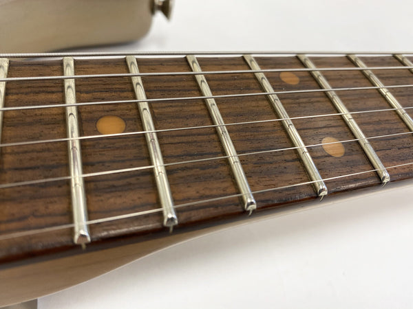 Close-up of guitar fretboard with metal frets and dot inlays on wooden neck, steel strings visible, Coffee House Guitars product detail image