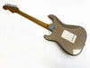 Back view of vintage electric guitar with worn brown finish and wooden neck on white background
