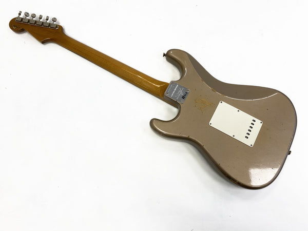Back view of vintage electric guitar with worn brown finish and wooden neck on white background