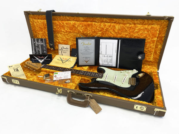 Fender Stratocaster electric guitar in brown sunburst finish inside vintage brown hard case with orange plush interior, including Fender certificate of authenticity, manuals, and accessories.