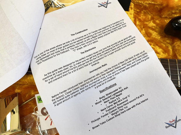 Close-up of a printed Fender Custom Shop guitar specification sheet detailing construction, electronics, Journeyman Relic finish, and specs including lightweight ash body, maple neck, rosewood fretboard, 9.5 radius, Custom Shop pickups, and brown tolex hard case on a textured yellow guitar case background.