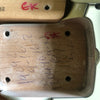Close-up of wooden guitar neck pocket with handwritten markings and red "EK" label on light-colored guitar body.