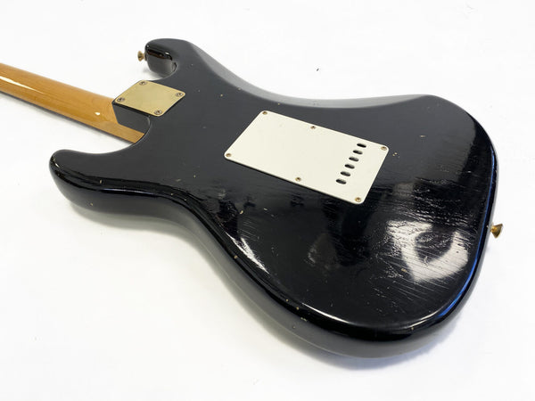 Vintage black electric guitar body with white backplate and maple neck on white background