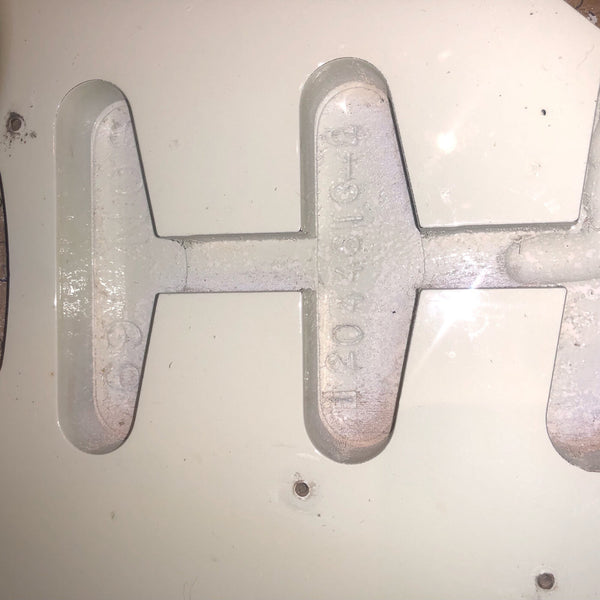 Close-up of cream-colored guitar body cavity with string ferrules and mounting holes for pickups or hardware, showing details of guitar construction and finish.