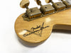 Close-up of vintage Fender Custom Shop guitar headstock with aged tuning pegs and logo on natural wood finish