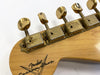 Close-up of vintage Fender Custom Shop guitar headstock with aged gold tuning pegs and worn "Fender Custom Shop" logo on natural wood finish