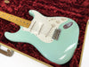 Seafoam green vintage electric guitar with maple neck and white pickguard in plush red guitar case