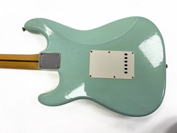 Close-up of the back of a blue electric guitar body showing the neck plate and rear cavity cover on clean white background