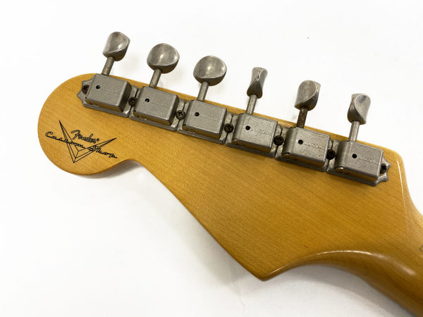 Close-up of the back of a Fender Custom Shop guitar headstock showing vintage-style tuning pegs and Fender Custom Shop logo on natural wood finish