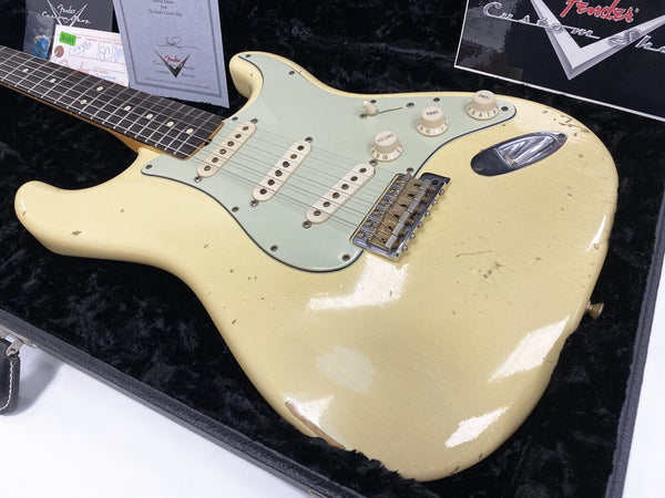 Vintage Fender Stratocaster electric guitar with aged cream finish and three single-coil pickups in black velvet-lined hard case