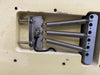 Close-up of vintage electric guitar tremolo cavity showing three metal tension springs and claw mounted on aged cream body wood with cracks and chip paint