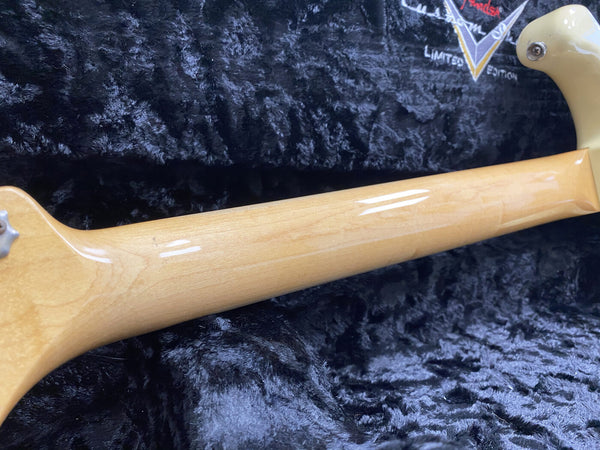 Glossy maple neck of a Fender electric guitar resting on a black plush guitar case interior