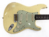 Vintage cream-colored electric guitar with three single-coil pickups, mint green pickguard, and rosewood fretboard showing signs of wear and aging