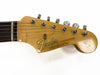 Fender Stratocaster guitar headstock with tuning pegs and strings, natural wood finish, original decal sticker, close-up view.