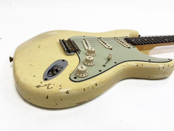Vintage cream electric guitar with relic finish, three single-coil pickups, and cream control knobs on white background