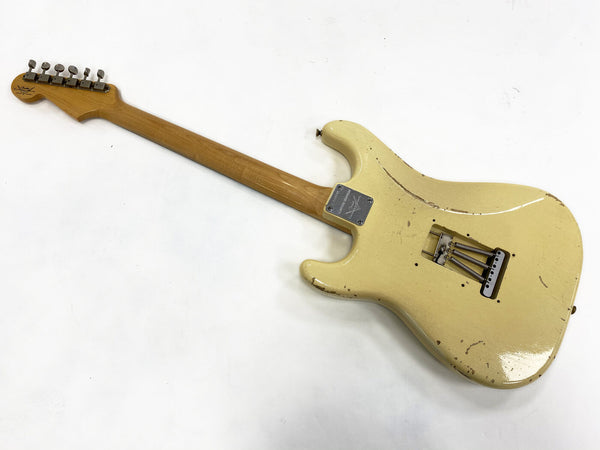 Vintage cream electric guitar body with maple neck and metal tuning pegs, back view showing wear and scratches, missing strings and rear tremolo springs exposed