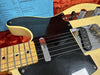 Close-up of vintage-style Telecaster electric guitar with cream body, black pickguard, maple neck, and chrome hardware on orange plush background with blue hardware and electronics note.
