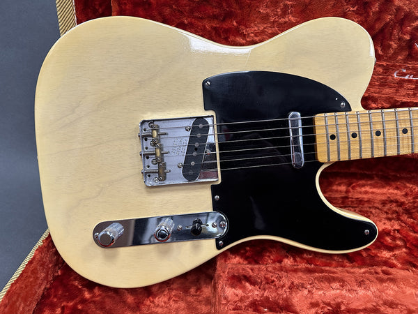 Vintage cream Fender Telecaster electric guitar close-up with black pickguard and chrome hardware in plush red case interior