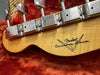 Close-up of Fender Custom Shop guitar headstock with vintage tuning pegs on orange plush lining