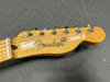Close-up of Fender electric guitar headstock with tuning pegs on gray background