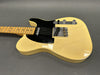 Vintage cream finish electric guitar with black pickguard and maple neck on gray background