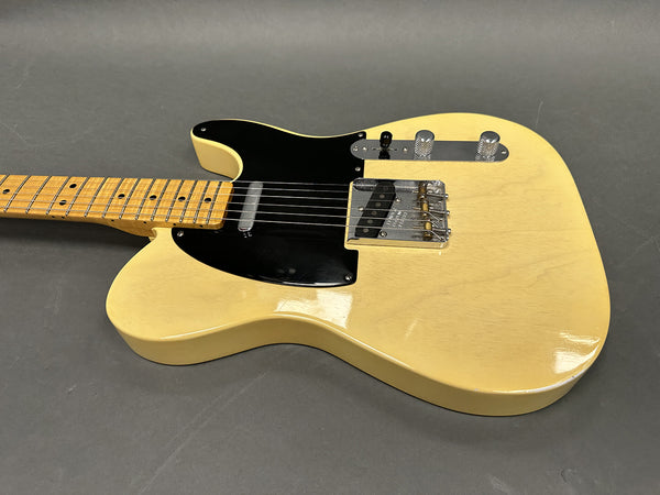 Vintage cream finish electric guitar with black pickguard and maple neck on gray background