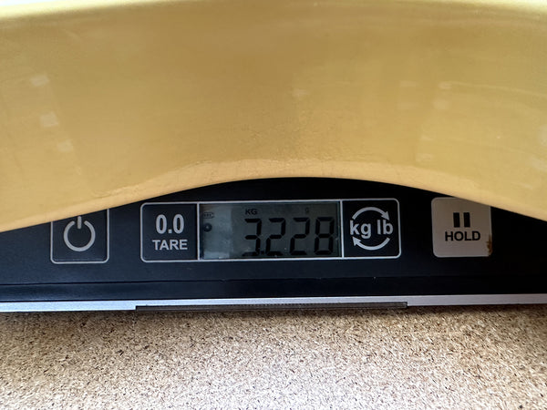 Digital scale showing acoustic guitar weight 3.228 kilograms at Coffee House Guitars product listing
