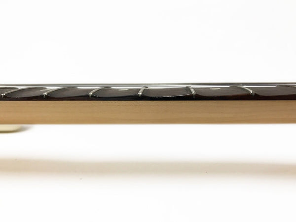 Close-up side view of guitar fretboard showing frets and strings on light wooden neck against white background