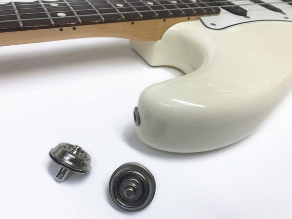 White electric guitar body with metal strap lock buttons detached, close-up view of guitar neck and strap button hardware on white background