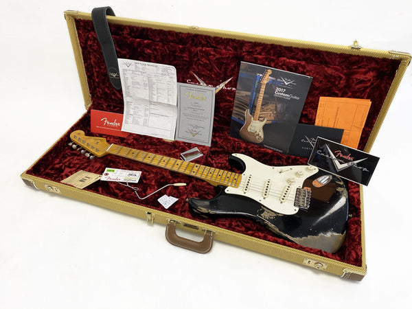 Fender Custom Shop Black Stratocaster electric guitar with aged finish in tweed hard case with red plush interior, vintage-style tremolo arm, Fender guitar certification documents and 2017 Custom Guitar Design Guide booklet