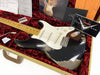 Fender Custom Shop black relic Stratocaster electric guitar with maple neck and white pickguard in vintage tweed hard case with red plush interior and Fender Custom Shop documentation.