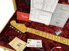 Fender Stratocaster guitar neck with tuners and maple fretboard inside red plush-lined hardshell case with Fender warranty card, certificate of authenticity, and setup tag