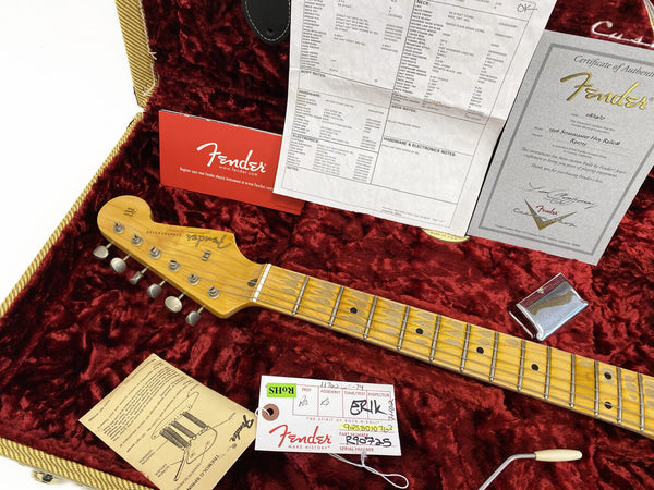 Fender Stratocaster guitar neck with tuners and maple fretboard inside red plush-lined hardshell case with Fender warranty card, certificate of authenticity, and setup tag