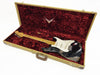 Black Fender Stratocaster electric guitar with maple neck and white pickguard in tan tweed hard case with red plush interior