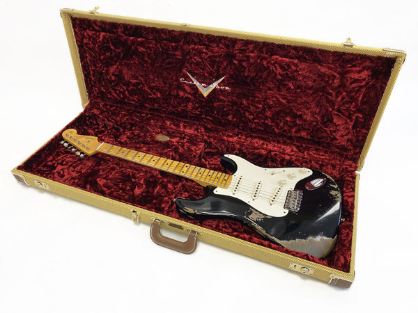 Black Fender Stratocaster electric guitar with maple neck and white pickguard in tan tweed hard case with red plush interior