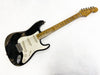 Fender Stratocaster electric guitar with black relic finish and maple neck on white background