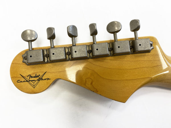 Close-up of vintage Fender Custom Shop guitar headstock with six metal tuning pegs on natural wood finish against white background