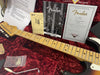 Fender Stratocaster Relic electric guitar neck and headstock close-up with owner's manual, tremolo springs diagram, certificate of authenticity, and guitar case interior with red plush lining and accessories.
