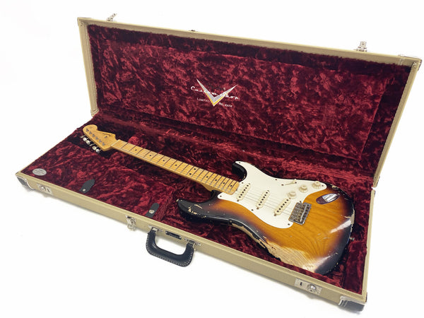 Fender Stratocaster electric guitar with sunburst finish and worn relic look inside vintage plush burgundy-lined hardshell guitar case
