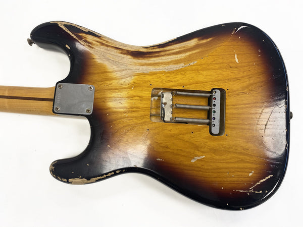 Vintage sunburst electric guitar body with visible wear and aging, showing metal spring cavity and neck plate, photographed on a white background