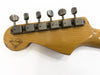 Vintage electric guitar headstock with six vintage tuning pegs and Dennis Galalley logo on natural wood finish